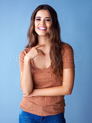 Buy stock photo Studio shot of beautiful young woman posing against a blue background