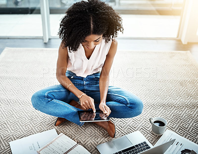 Buy stock photo High angle shot of an attractive young businesswoman working on her tablet in her home office