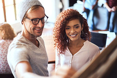 Buy stock photo Shot of two businesspeople discussing their ideas on a blackboard