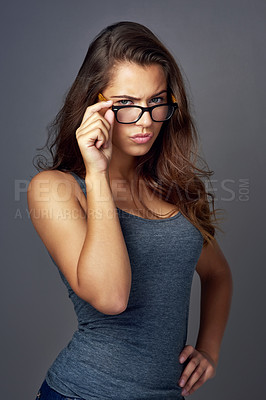 Buy stock photo Portrait, glasses and woman with confidence, upset and optometry on gray studio background. Face, person and model with eyewear, sight and looking with clear vision, frustrated and emotion with anger