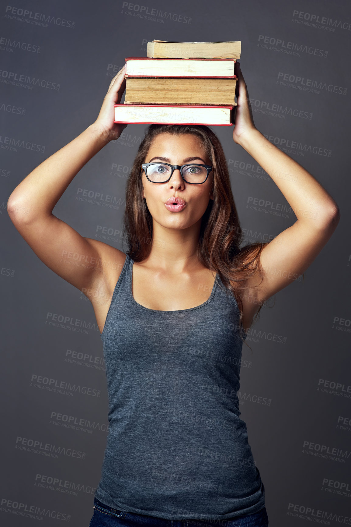 Buy stock photo Portrait, head and student balance books for learning, education and surprise isolated on gray studio background. Woman, university or textbook pile for knowledge, information or shocked with glasses