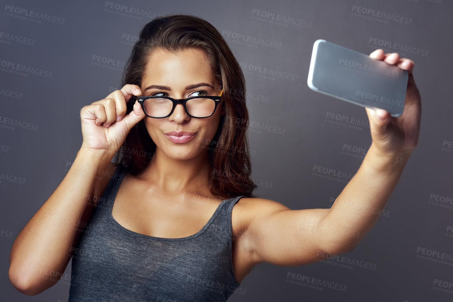 Buy stock photo Woman, glasses and selfie with confidence, optometry and playful on gray studio background. Female person, memory and happy for eyewear, sight and social media with pout, clear vision and eye care