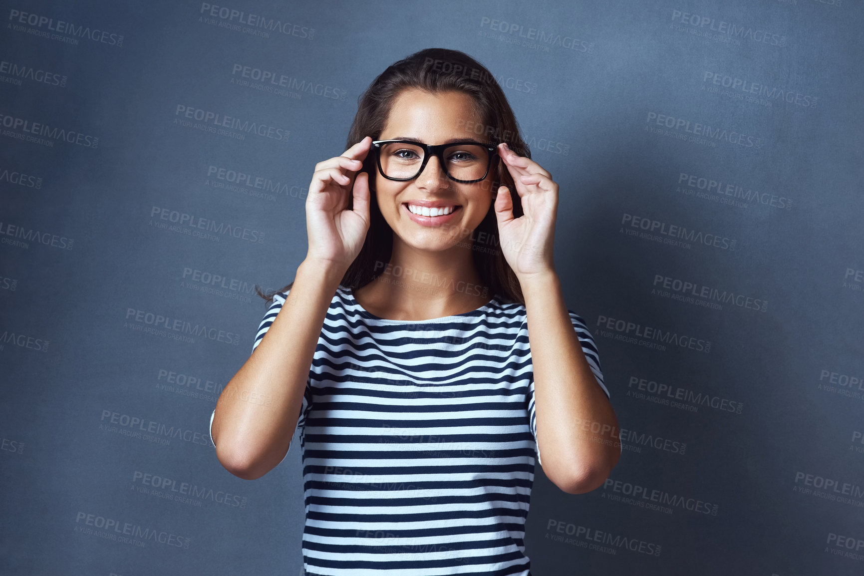 Buy stock photo Girl, portrait and glasses in studio for eye care with prescription lens for eyesight, optometry and healthcare. IT professional, happy and blue background with spectacles for vision and space.