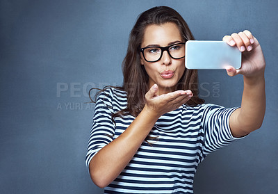 Buy stock photo Woman, glasses and selfie with air kiss, optometry and confidence on gray studio background. Female person, memory and happy for eyewear, social media and smile with post, clear vision and eye care