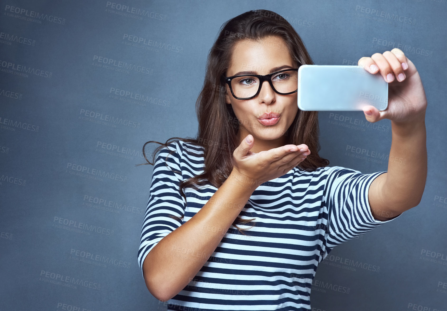 Buy stock photo Woman, glasses and selfie with air kiss, optometry and confidence on gray studio background. Female person, memory and happy for eyewear, social media and smile with post, clear vision and eye care