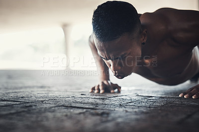 Buy stock photo Cropped shot of a handsome young man doing pushups while exercising outside