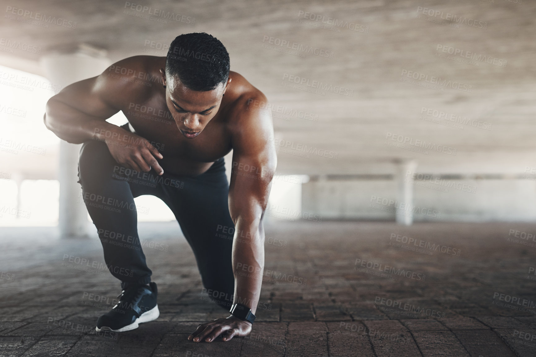 Buy stock photo Black man, athlete and outdoor or start exercise with muscle in parking garage for cardio, fitness or strength. Male person, ground and shirtless for summer run is sportswear, wellness or training