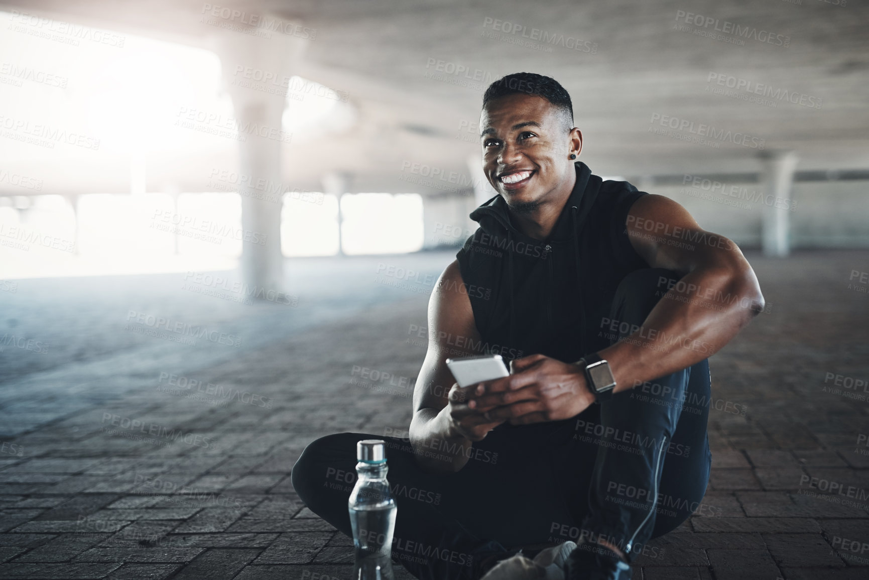 Buy stock photo Cropped shot of a handsome young man sending a text while exercising outside