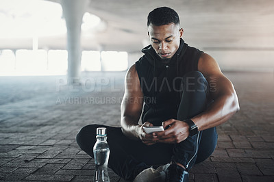 Buy stock photo Black man, phone and break from workout in city with texting, reading or relax on ground with fitness. African person, smartphone and runner with contact, app or social media on concrete in New York