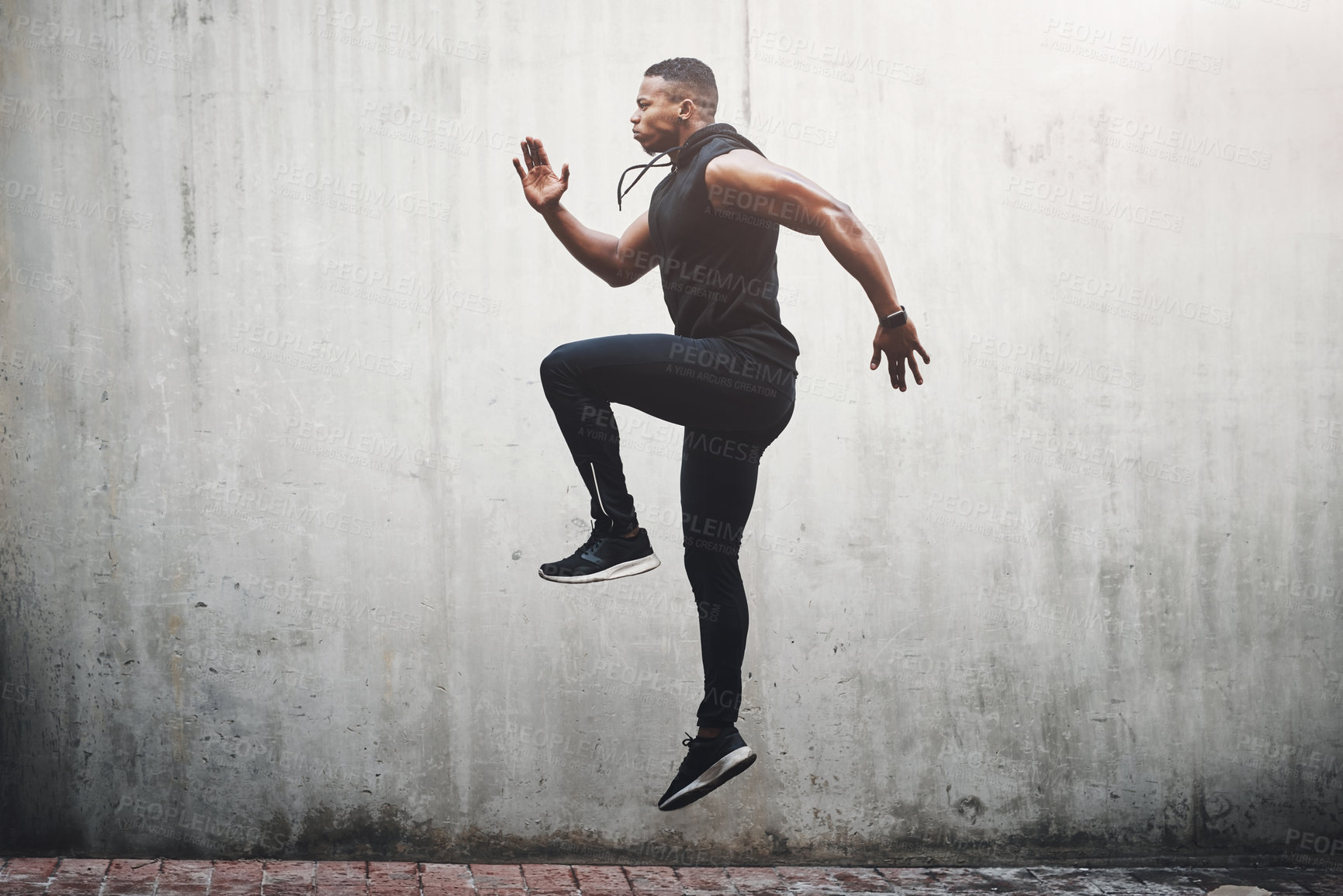 Buy stock photo Full length shot of a handsome young man skipping on the spot while exercising outside