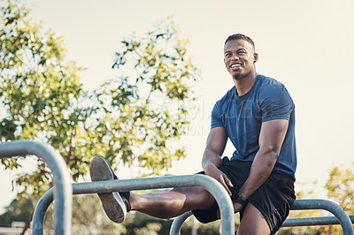 Buy stock photo Cropped shot of a handsome young man sitting at a calisthenics park while exercising outside