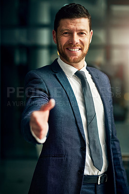 Buy stock photo Cropped portrait of a handsome young businessman extending a handshake in an office
