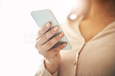 Buy stock photo Phone in hand, communication and networking with a woman reading, typing or sending a text message. Closeup of a female browsing social media, surfing the internet and checking news online with flare