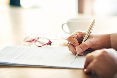 Buy stock photo Cropped shot of an unrecognizable businesswoman filling in paperwork in an office