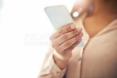 Buy stock photo Cropped shot of an unrecognizable businesswoman using a cellphone in an office