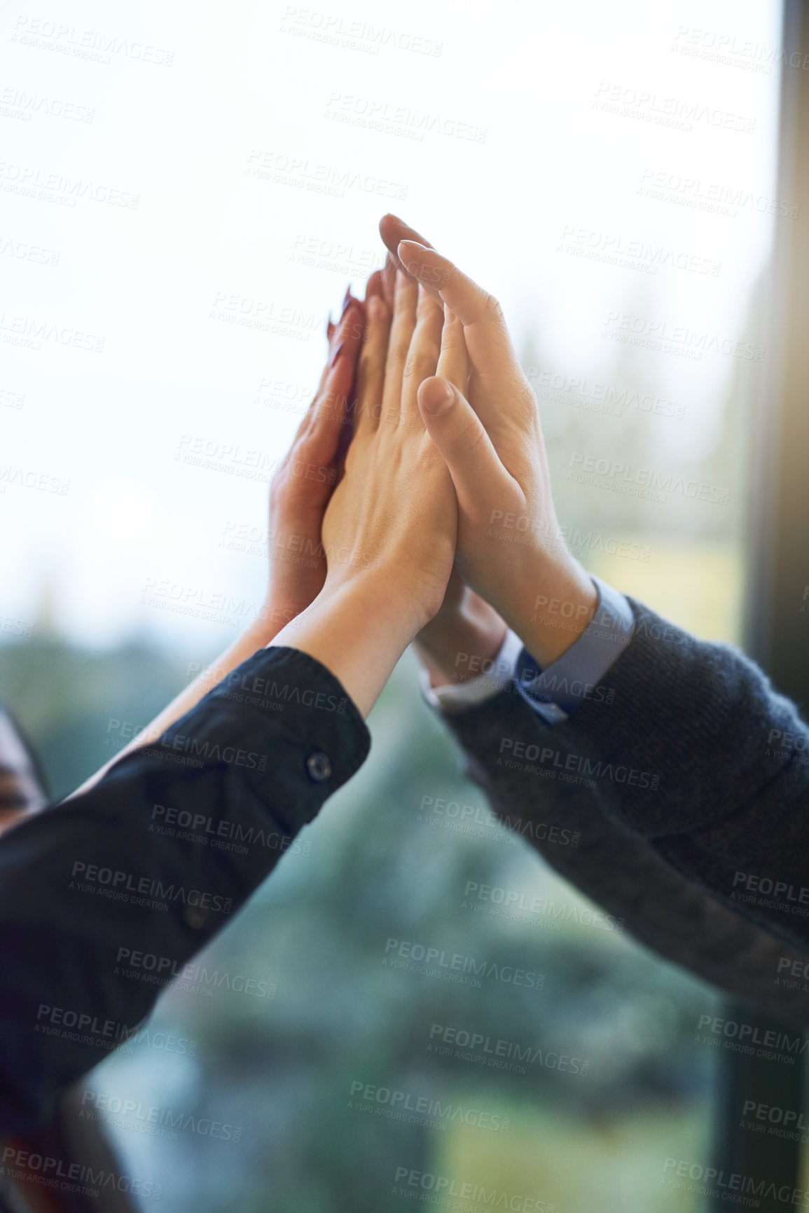 Buy stock photo Cropped shot of a group of unrecognizable businesspeople giving each other a high five in an office