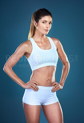 Buy stock photo Studio shot of a fit young woman posing against a blue background