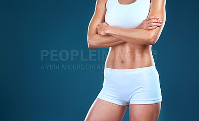 Buy stock photo Studio shot of an unrecognizable fit woman posing against a blue background