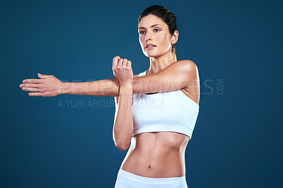 Buy stock photo Studio shot of a fit young woman posing against a blue background