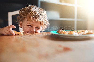 Buy stock photo Cropped shot of an adorable little boy eating at home