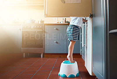 Buy stock photo Small, looking and a child on a step for refrigerator food, breakfast or a snack in a house. Kitchen, morning and a little kid standing on a chair to look for a meal or lunch in the fridge for hunger