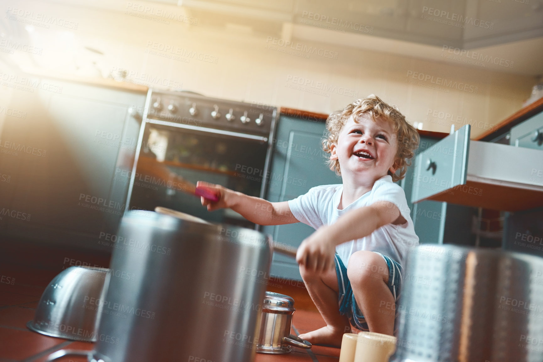 Buy stock photo Happy, child and drums on pots in kitchen as creative talent, music or sound as musician of childhood learning. Smile, boy and playing on fantasy instrument of game activity for sensory development