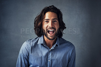 Buy stock photo Studio portrait of a handsome young man shouting while posing against a grey background