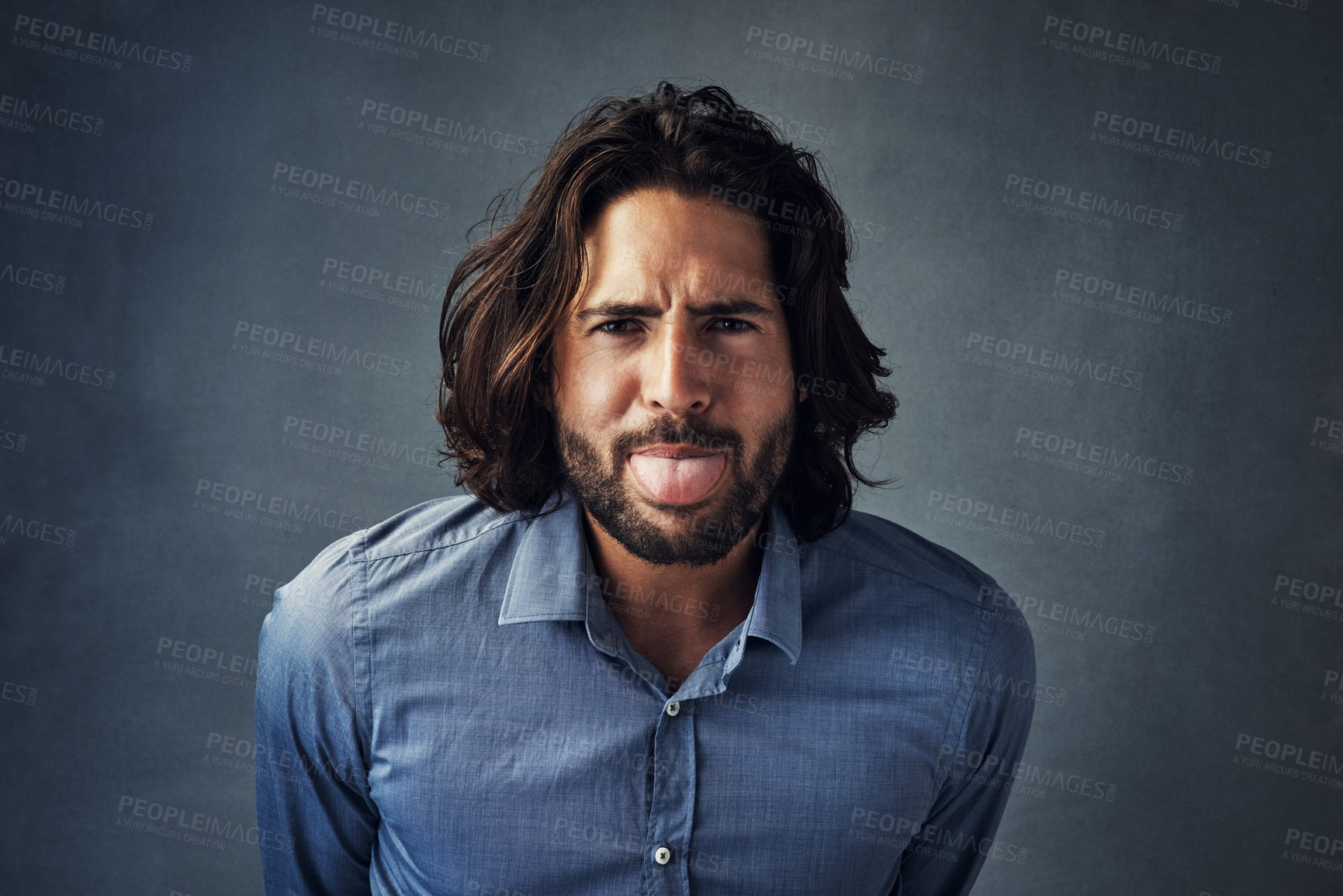 Buy stock photo Tongue out, playful and portrait of man in studio with silly, goofy and funny face on dark background. Playing, emoji and person with crazy facial expression for comic, humor and joke for reaction