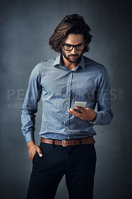 Buy stock photo Studio shot of a handsome young man using a digital tablet against a gray background