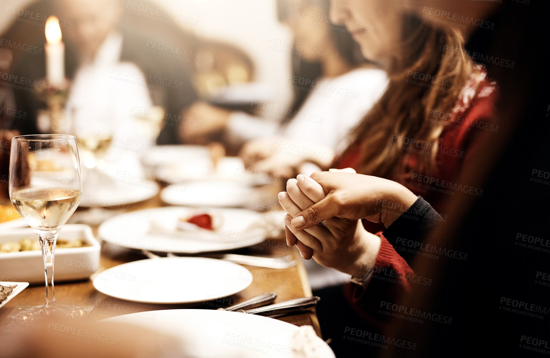 Buy stock photo Cropped shot of unrecognizable people holding hands in prayer before having a Christmas lunch together