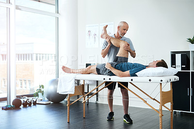 Buy stock photo Full length shot of a handsome mature male physiotherapist treating a patient