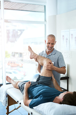 Buy stock photo High angle shot of a handsome mature male physiotherapist treating a patient