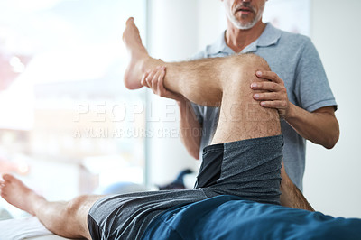 Buy stock photo Cropped shot of an unrecognizable mature male physiotherapist treating a patient