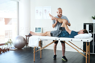 Buy stock photo Full length shot of a handsome mature male physiotherapist treating a patient