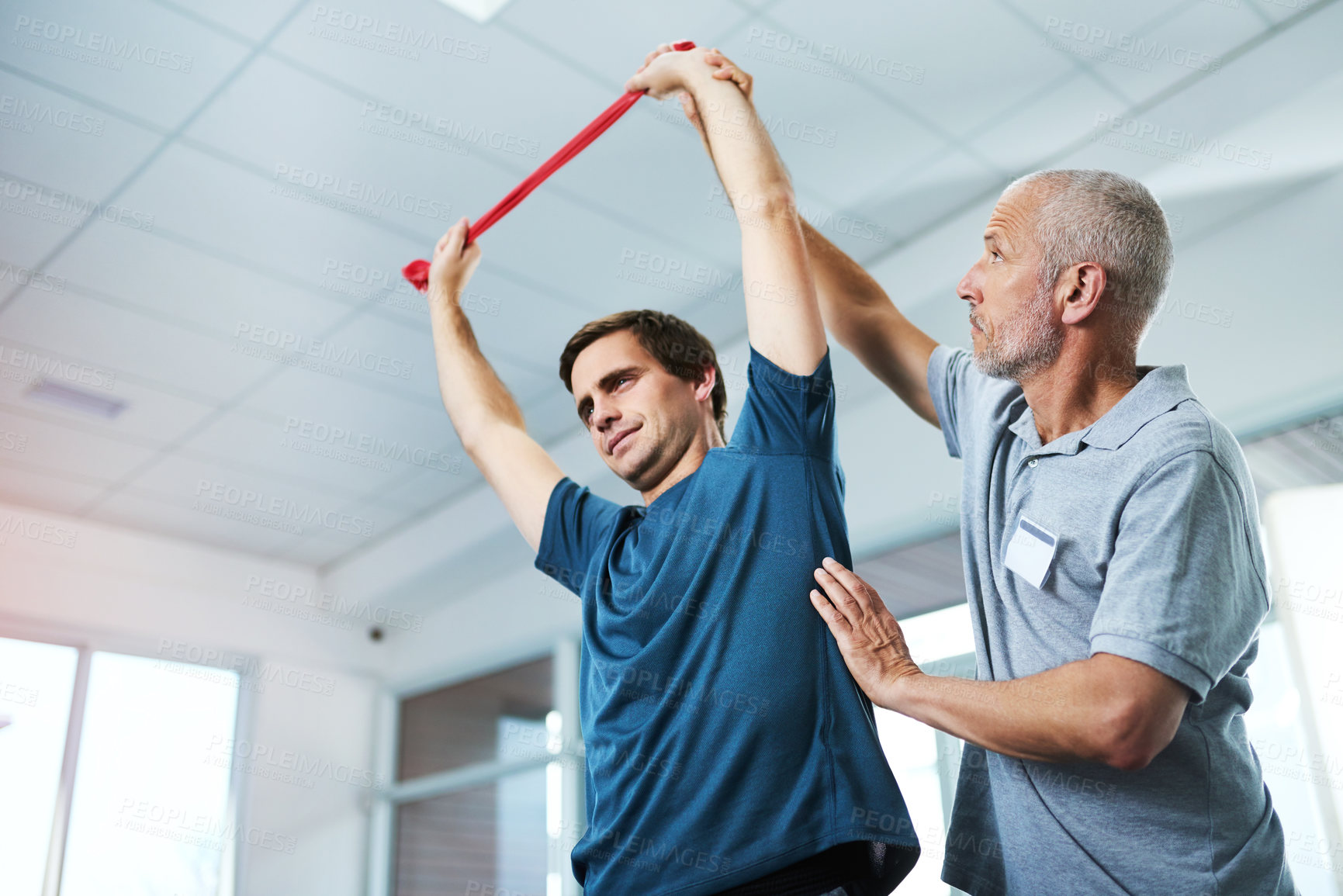 Buy stock photo Resistance band, stretching or training and man with physiotherapist in office for appointment or checkup. Exercise, fitness and physiotherapy professional with strong patient in rehab clinic