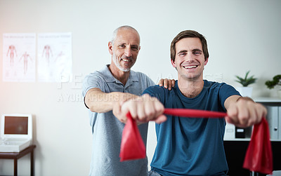 Buy stock photo Cropped portrait of a handsome mature male physiotherapist helping a patient stretch with resistance bands