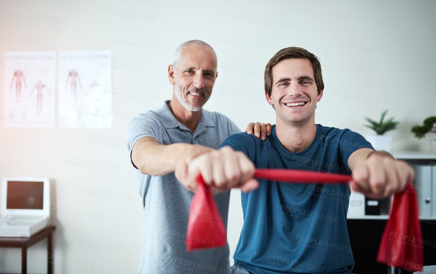 Buy stock photo Cropped portrait of a handsome mature male physiotherapist helping a patient stretch with resistance bands