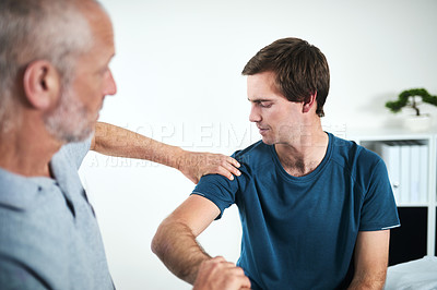 Buy stock photo Cropped shot of a mature male physiotherapist treating a patient