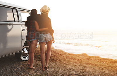 Buy stock photo Rearview shot of two young friends stopping at the beach during their roadtrip