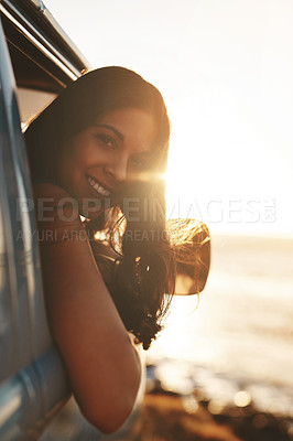 Buy stock photo Shot of an attractive young woman enjoying a road trip