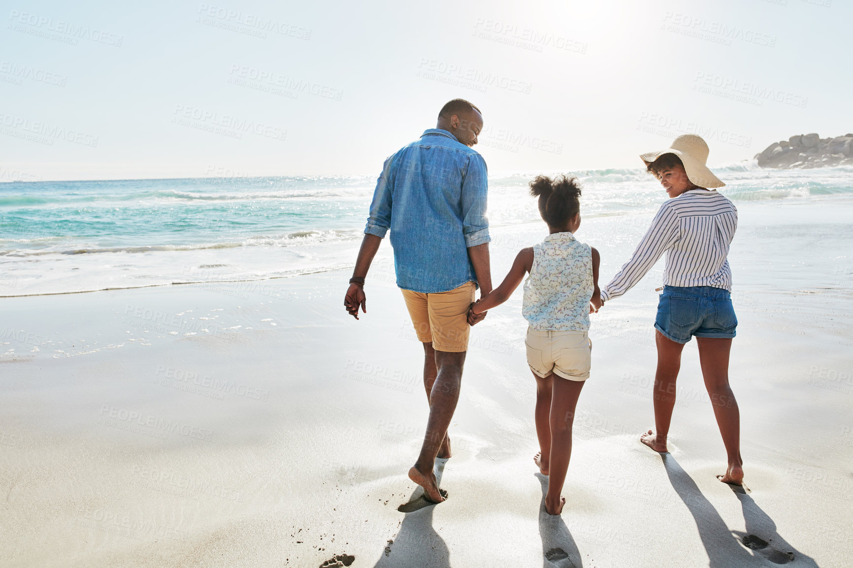 Buy stock photo Happy family, back and holding hands with child on beach for bonding, holiday or outdoor weekend. Mother, father and daughter walking in sunshine together for fun summer by ocean coast in nature