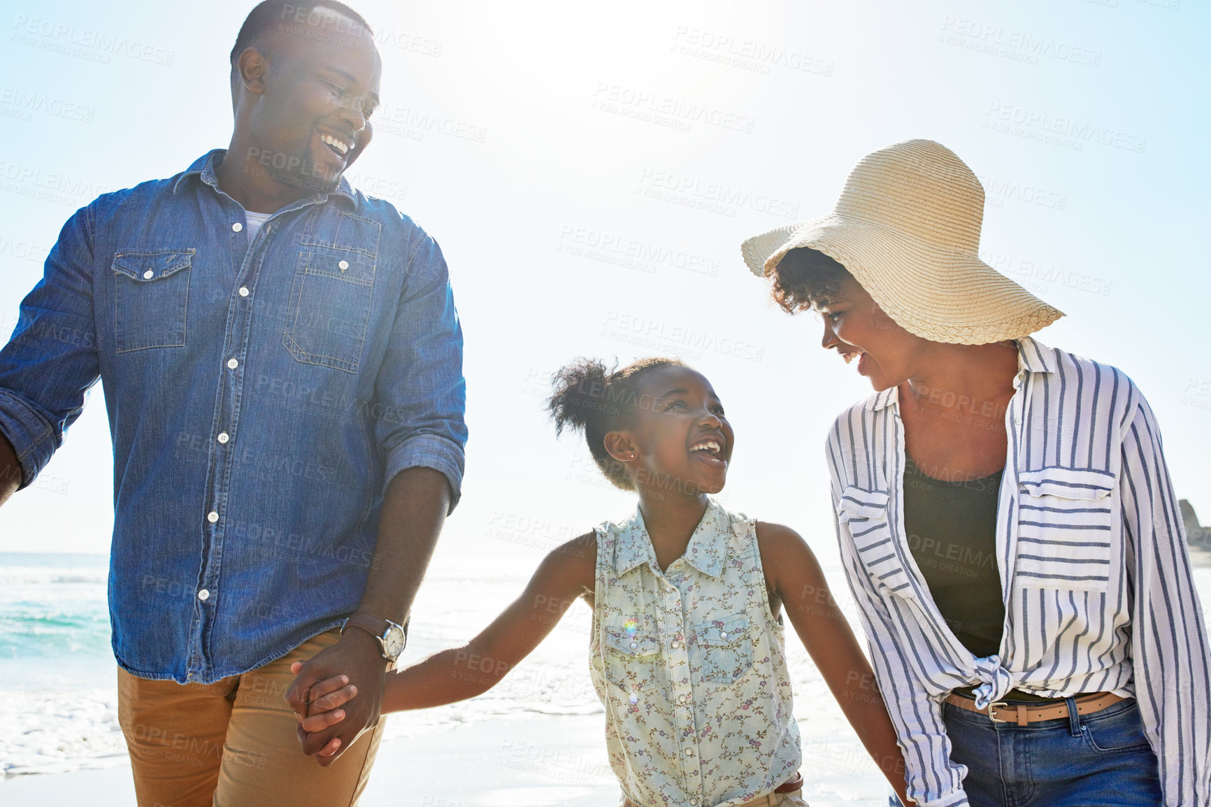 Buy stock photo Black family, happy and walking on a beach with child or kid on vacation or holiday at the ocean or sea. Travel, sunshine and African parents relaxing with daughter holding hands together on a trip