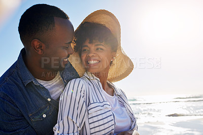 Buy stock photo Shot of a happy young couple enjoying a day at the beach together