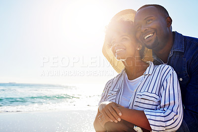 Buy stock photo Shot of a happy young couple enjoying a day at the beach together