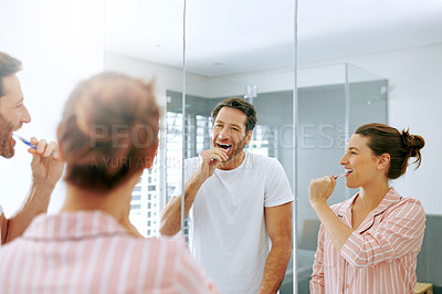 Buy stock photo Cropped shot of a couple brushing their teeth in the bathroom at home together