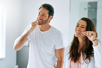 Buy stock photo Cropped shot of a couple brushing their teeth in the bathroom at home together