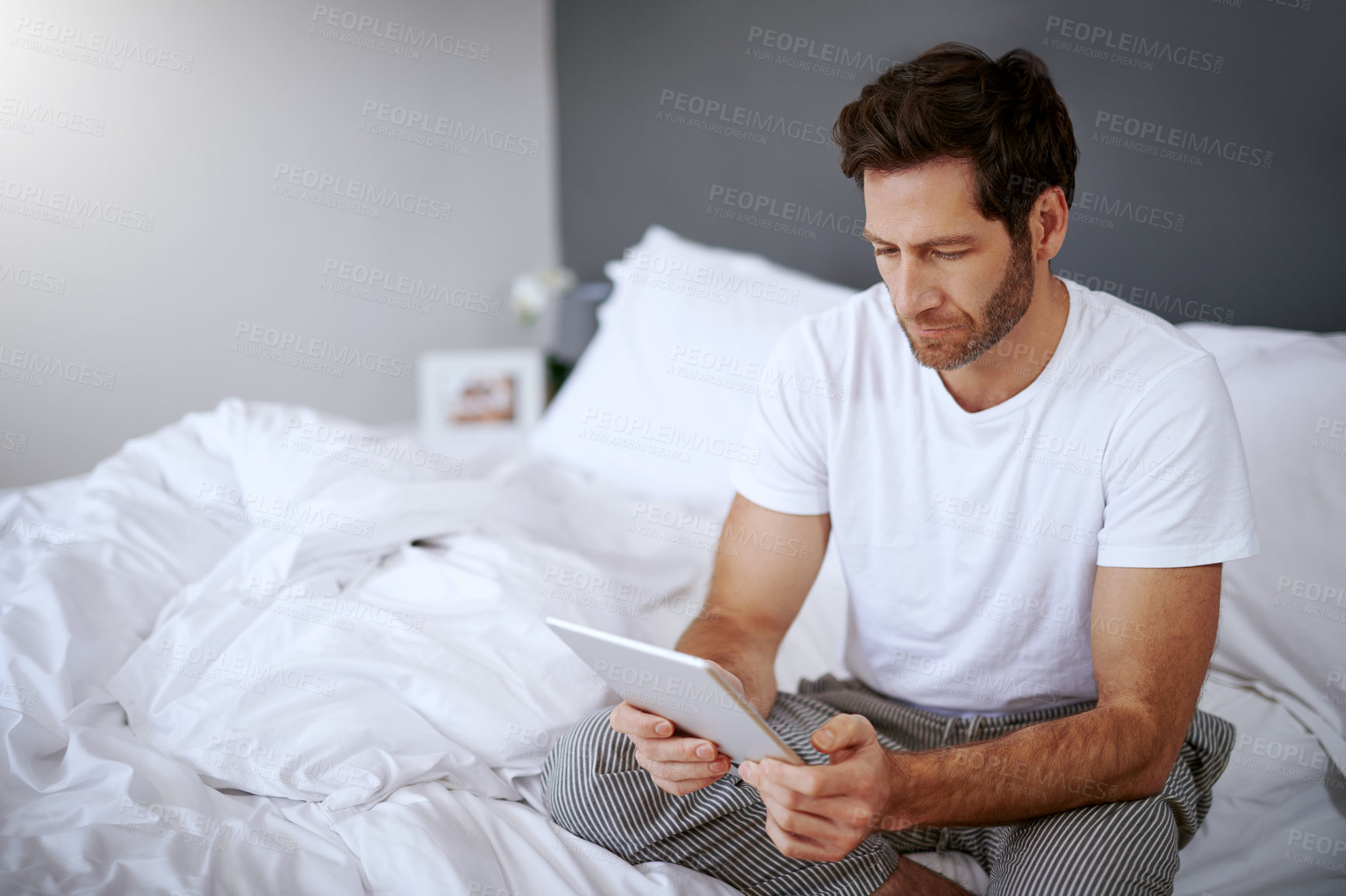 Buy stock photo Bed, relax and man with tablet in home for online search, connectivity and reading email in morning. Media, app and male person with tech in house for digital message, communication and notification