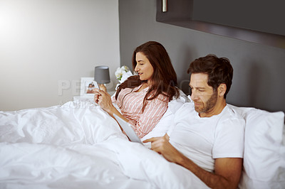 Buy stock photo Cellphone, tablet and couple in bed in home scrolling, browsing and networking on social media in morning. Rest, digital technology and phone with man and woman relaxing in bedroom at house.