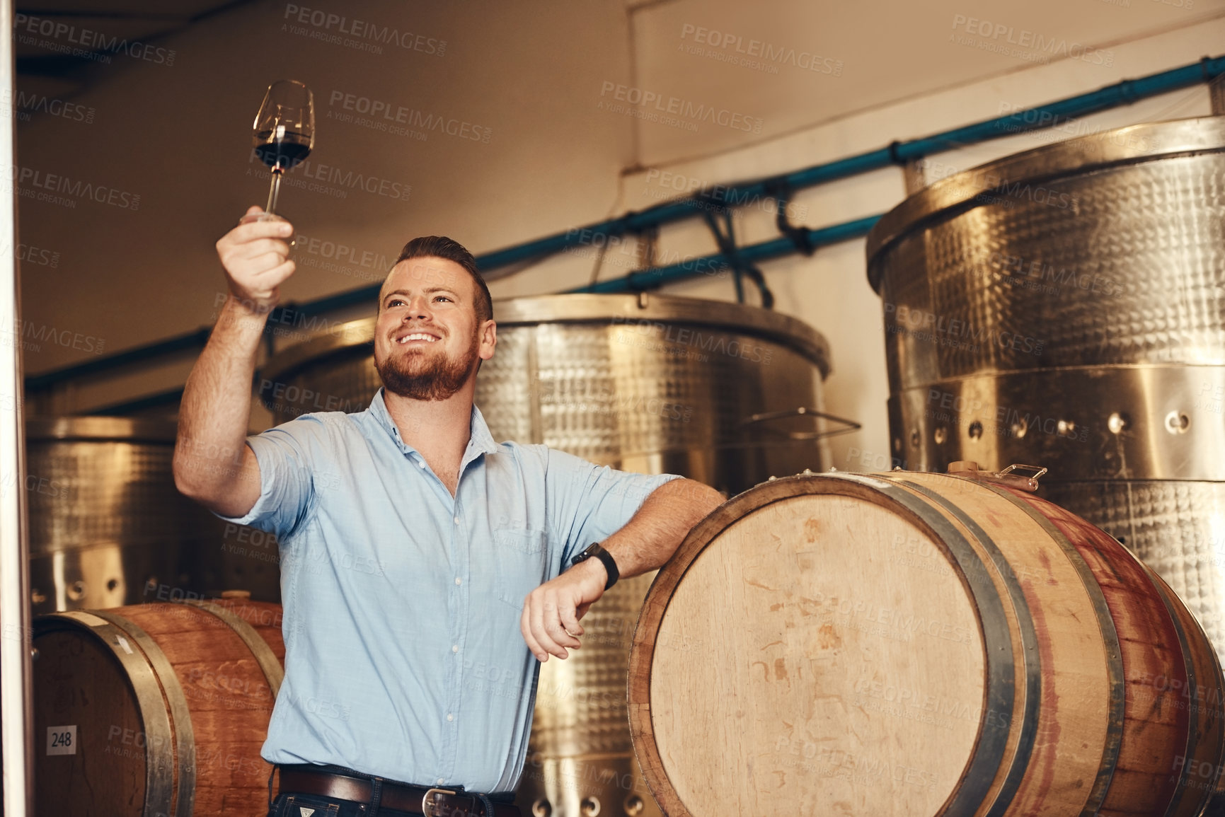 Buy stock photo Glass, proud and smile with man in wine cellar for industry, manufacturing or production. Barrel, business and smile with happy sommelier at winery to complete distillation or fermentation process