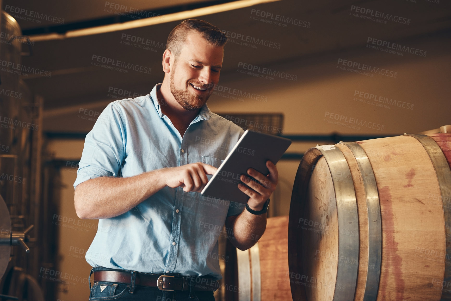 Buy stock photo Business, man and happy with tablet in brewery as manager with pride on product, process and schedule for supplier. Employee, barrel and smile for beer production, manufacturing or craft in factory